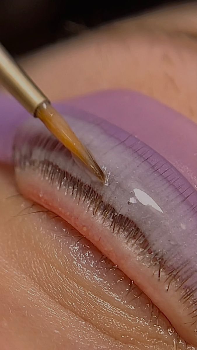 A professional lash formula being applied to aligned lashes