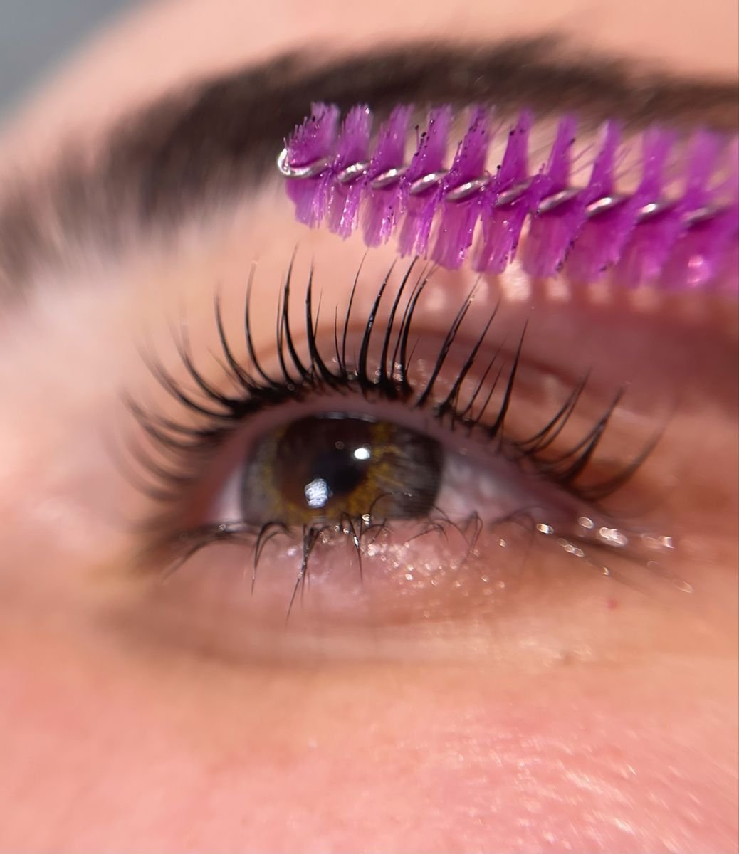 A lash brush separating lifted eyelashes