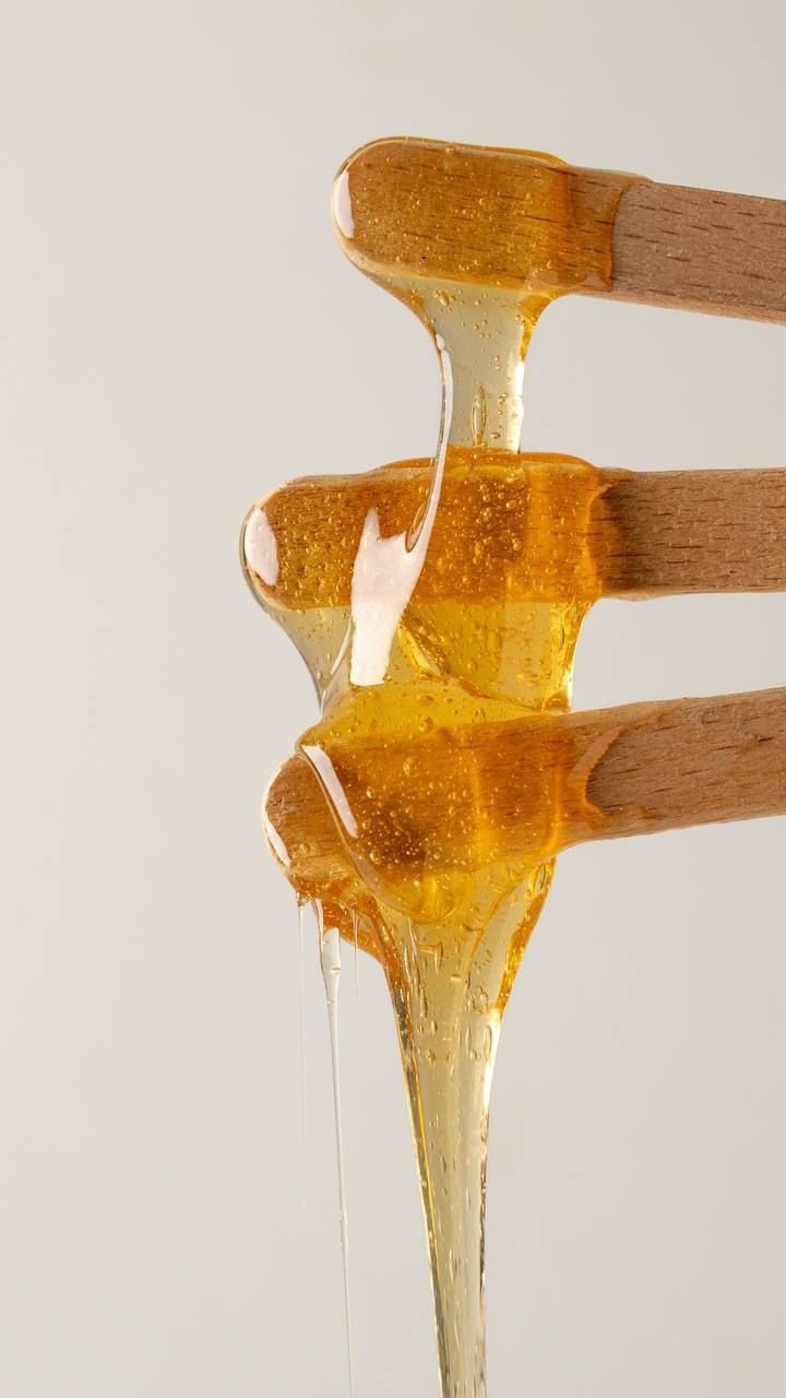 Warm facial wax on wooden spatulas